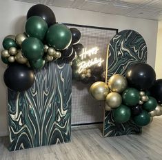 some balloons that are in the shape of heart shaped shapes and black, gold and green balloons