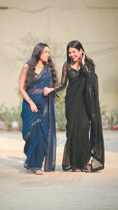 two women in sari talking on their cell phones