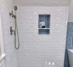 a white tiled bathroom with blue and white tiles