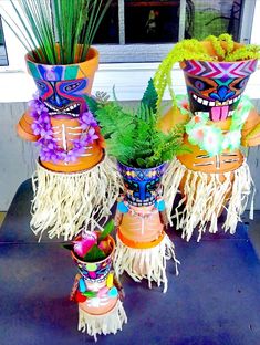 four pots with plants in them on a table outside the window sill, decorated with grass and flowers