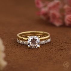 a close up of a ring with a diamond on it and flowers in the background