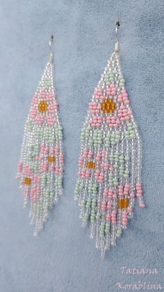 two pairs of beaded earrings with pink, green and white beads hanging from hooks