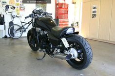 a black motorcycle parked inside of a garage