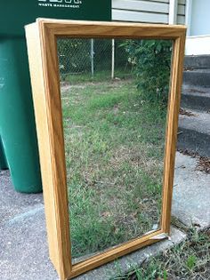 a mirror sitting on the ground in front of a house