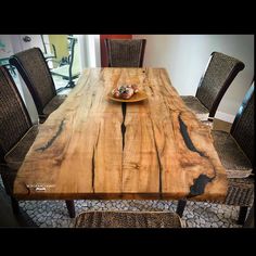 a wooden table with chairs around it and a plate of food on top of it