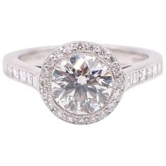 a white gold engagement ring with diamonds on the band and round brilliant cut center stone