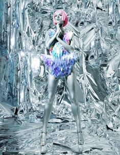 a woman with pink hair is standing in front of silver foil