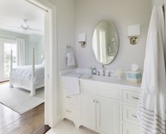 a white bathroom with two sinks and mirrors