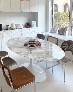 a kitchen with a marble table and chairs