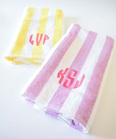 two towels with monogrammed letters on them sitting next to each other in front of a white background