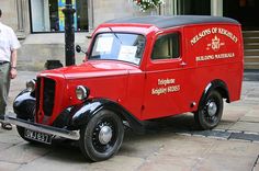 an old red truck is parked on the street