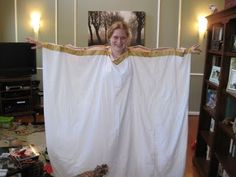 a woman standing in front of a white curtain with her arms spread out and two birds sitting on the floor