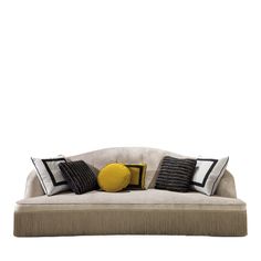 a white couch with black and yellow pillows sitting on it's backrests