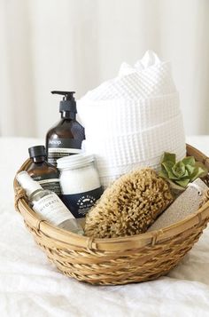 a wicker basket filled with personal care items on top of a white bed sheet