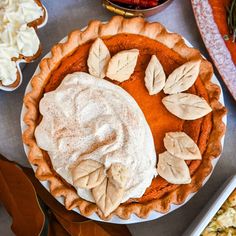 there is a pie on the table with other desserts and pastries around it