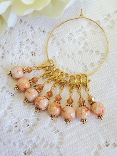 a close up of a necklace on a lace table cloth with flowers in the background