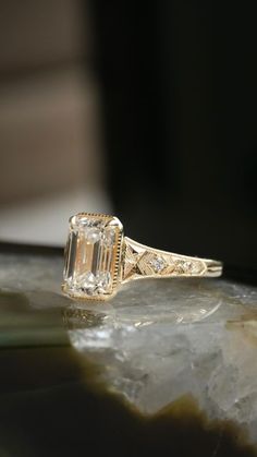 an old - fashioned diamond ring sits on top of a rock