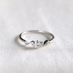 a diamond ring sitting on top of a white cloth