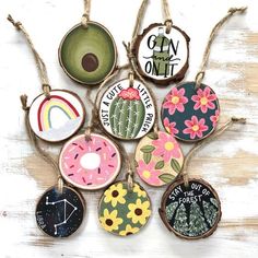 a bunch of different types of ornaments hanging on a wooden table with string and wood slices