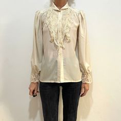 1970's or 80's Ted Lapidus rayon lace Victorian blouse.  Perfect boho elegance.  Very talitha Getty in Morocco.  The fabric feels like a fine rayon, a little bit silky but I think it may have some poly in it. Slightly sheer.  Nylon lace.  High lace neck.  Blouse is cut straight with no darts. Gathers at the shoulders for fullness.  Also gathers at the sleeve caps for a full sleeve.  Five plastic buttons up the front.  Elastic at the sleeve cuff.  Label Ted Lapidus Diffusion. Made in France. No content label, feels like a poly rayon mix, has a nice touch. Lace is nylon.  Dry clean only. Iron low heat.  Good vintage condition with no fabric or sewing flaws.  Measurements Shoulders 40cm/ 13inches Chest 110cm/ 43inches Waist 110cm/ 43inches Shoulder to hem 65cm/ 25inches Sleeve length 64cm/ 25 Vintage Blouse With Lace Sleeves, Vintage Lace Blouse For Fall, Vintage Party Blouse With Lace Sleeves, Vintage Blouse With Lace Sleeves For Parties, Vintage Lace Top With Lace Collar For Party, Vintage Lace Blouse For Spring, Fitted Vintage Lace Top For Fall, Vintage Fashion Blouse With Lace Trim, Vintage Fitted Blouse With Lace Patchwork