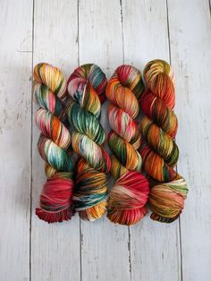 several skeins of multicolored yarn laid out on a white wooden surface