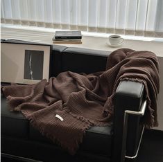 a couch with a blanket on it next to a window