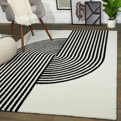 a black and white area rug in a living room with pictures on the wall behind it