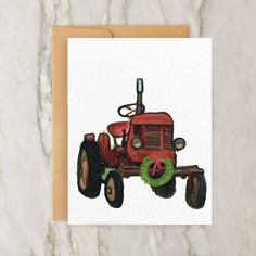 a red tractor with a wreath on it's front sits on a marble surface