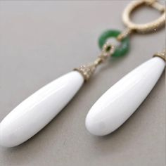 A stylish and chic pair of drop earrings! They feature 27.35 carats of smooth drop-shaped white onyx. Accenting them are 0.41 carats of round brilliant-cut diamonds which add sparkle and brilliance to the piece. Finishing the earrings are two jadeite jade hoops which add length and contrast in color to this unique piece. Made in 18k rose gold and ready to be enjoyed.      Length: 2.5 inches    Weight: 9.2 grams White Diamond Earrings For Formal Occasions, Formal White Diamond Gemstone Earrings, White Diamond Gemstone Earrings For Formal Occasions, Timeless White Earrings With Diamond Accents, Luxury White Oval Earrings, Luxury Teardrop Diamond Earrings, Luxury White Drop Teardrop Earrings, White Gemstone Diamond Earrings In Fine Jewelry Style, White Diamond Drop Earrings With Accents