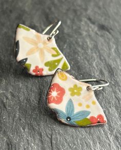 White enameled copper earrings with a bright,multicolored floral design. A sweet gift for a special gardener in your life. Approximate measurements: Enamel dangle: 1-1/2" x 7/8" Hang length: 1-3/8" Sterling silver earwires. To create these earrings, multiple layers of finely powered glass are fused to the copper using a torch flame. The floral design is added by firing a beautifully detailed decal onto the final layer of glass. We love making fun, boho inspired jewelry and hope you love wearing them. See more of our copper and enameled copper earrings & pendants here: www.etsy.com/shop/blueberrybayjewelry Whimsical Multicolor Flower Shaped Jewelry, Multicolor Floral Print Flower Earrings, Multicolor Flower Earrings For Spring Gift, Whimsical Multicolor Flower-shaped Earrings, Colorful Earrings As Spring Gift, Unique Multicolor Flower Earrings Gift, Colorful Spring Earrings As Gift, Colorful Spring Earrings For Gift, Colorful Spring Earrings For Gifts