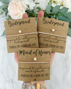 three bridesmaid gift tags in hand with flowers and greenery on the side