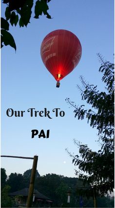 a red hot air balloon in the sky with text over it that reads our trek to pai