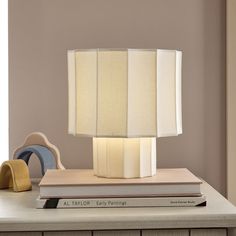 a lamp sitting on top of a table next to a stack of books