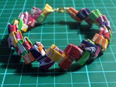 a bracelet made out of candy bars on top of a green table with a knife