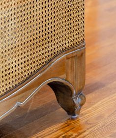 a close up view of the corner of a chair with wood flooring and fabric