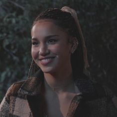 a woman with braids smiling at the camera