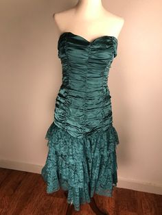 This amazing teal colored vintage silk Betsey Johnson Evening gown is like a glass of fine champagne in candle light. It's beautifully ruched bodice of satiny silk flows down low over the hips where it meets three gathered layers of matching  Floral lacy tulle. It has a back zipper and the bodice is lightly boned. The skirt has three layers of lining. Gorgeous dress! It is in very good preowned condition. It is a size 10 but keep in mind that Betsey's clothes tend to run small. Measurements are Green Silk Evening Dress With Pleated Bodice, Green Ruched Evening Dress For Formal Occasions, Green Ruched Evening Dress For Wedding, Green Silk Evening Dress With Ruched Bodice, Silk Evening Dress With Ruched Bodice For Prom Season, Vintage Ruched Dress With Fitted Bodice, Vintage Satin Evening Dress With Fitted Bodice, Vintage Satin Dress With Pleated Bodice, Vintage Silk Evening Dress With Fitted Bodice