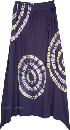 An ultra-cool bohemian maxi skirt with a high low hemline in a chic berry blue color with a beautiful tie and dye pattern. The tie-dye effect is created in the shape of concentric circles in white color blended with soft hues of pink and yellow. This ripple effect looks unique and very gypsy. Simply wear this skirt with a solid colored tank top and you are ready for your casual summer day, a fun beach party or an evening out with friends. Another distinctive feature of this skirt is its side dra Bohemian Batik Print Skirt For Summer, Summer Bohemian Batik Print Skirt, Bohemian Batik Print Summer Skirt, Purple Bohemian Maxi Skirt For Vacation, Bohemian Purple Maxi Skirt For Vacation, Bohemian Purple Maxi Skirt For The Beach, Purple Maxi Skirt For Summer Vacation, Spring Tie Dye Long Maxi Skirt, Spring Tie Dye Maxi Skirt