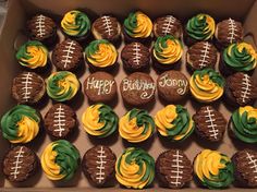 a box filled with chocolate cupcakes covered in green and yellow frosting