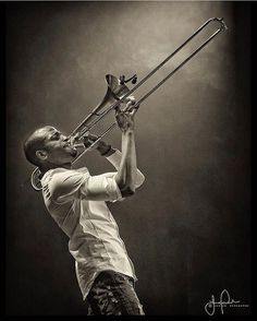 a man playing the trombone in black and white