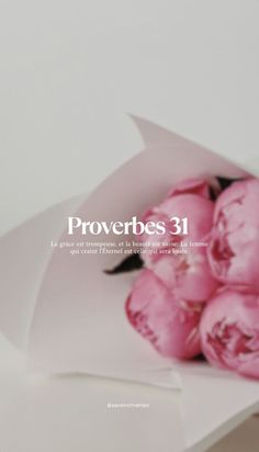 a bouquet of pink flowers sitting on top of a white paper bag with the words proverbes 31