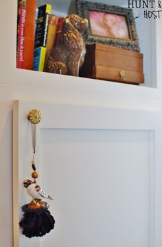 there is a key chain hanging from the wall next to a book shelf with books on it