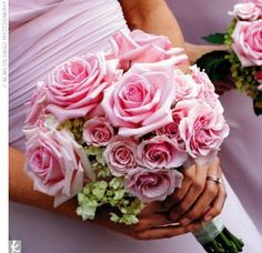 two bridesmaids holding bouquets of pink roses