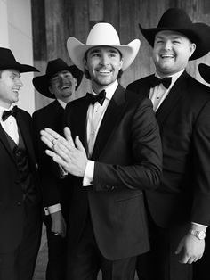 black and white photograph of three men in suits, one wearing a cowboy hat while the other wears a tuxedo