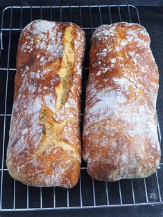 two loaves of bread sitting on top of a cooling rack