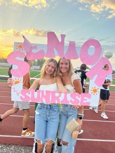 two girls are standing in front of a sign