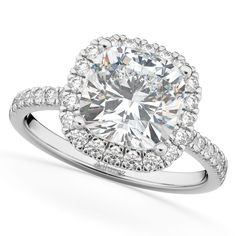 a white gold ring with an oval cut diamond surrounded by round diamonds