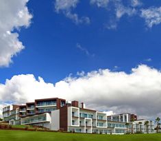 a large building with many balconies on the top of it and palm trees in front