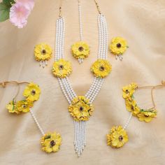 the necklaces are decorated with yellow flowers and pearls, along with matching bracelets