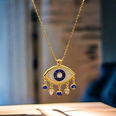 Inspired from Santorini island, a beautiful 18k yellow gold dangle and drop necklace with one pearl white enamel eye pendant lined with natural white diamonds weight in total 0.11 cts., and natural blue sapphires weighting 0.17 cts., tied on a 18 yellow gold long chain. Weight of 18k solid gold : 2.70 gr. (Adjustable) length of the Eye chain necklace: 39.0 - 42.0 cm. / 15.35 - 16.53 inch. Dimensions of the eye pendant: 1,3 * 0.8 cm. / 0.51 * 0.31 inch. Dynamic eye shaped pearl white enamelled solid gold charm custom made in our workshop in the historical center of Athens, in Greece. An easy-to-wear yellow gold smalto necklace with natural sapphires and diamonds, accompanied with an elegant jewelry box and gift packaging.  We combine it with MELIGreece's 18k gold necklace/ bracelet with tur Luxury Gold Plated Dangle Necklaces, Yellow Gold Necklaces With Detachable Cubic Zirconia Pendant, Yellow Gold Necklace With Detachable Cubic Zirconia Pendant, Gold Plated Gemstone Dangle Necklaces, Gold Dangle Jewelry With Evil Eye, Yellow Gold Jewelry With Pearl Pendant Dangle, Gold Cubic Zirconia Jewelry With Evil Eye Detail, Gold Cubic Zirconia Jewelry With Evil Eye, Luxury Evil Eye Pendant Jewelry